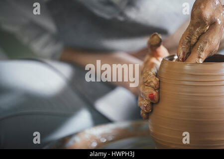 Sezione mediana della femmina di sagomatura del potter argilla sulla ruota di filatura in officina Foto Stock