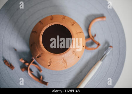 Vista aerea del vaso di creta e il pennello sulla tavola in officina Foto Stock