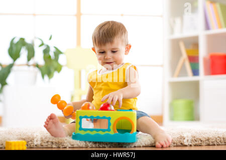 Funny baby boy studiando nursery room Foto Stock