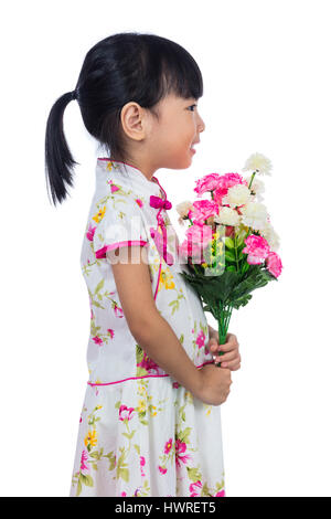 Cinese asiatici bambina indossa cheongsam azienda garofani saluto di fiori per la festa della mamma in isolati sullo sfondo bianco. Foto Stock