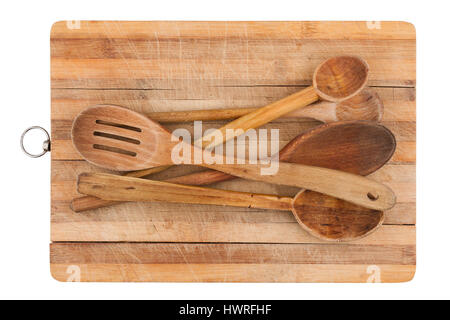 Vista superiore della mano in legno cucchiai da cucina in molte forme e dimensioni su un legno tagliere isolato su bianco Foto Stock