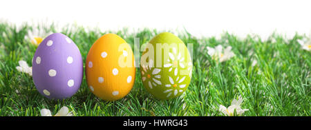 Grappolo di uova di pasqua in colori pastello su erba, isolati su sfondo bianco Foto Stock