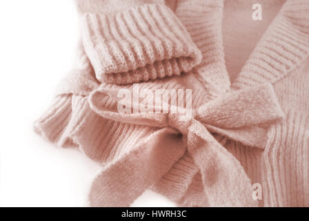 Close-up di design elegante a maglia rosa donna cardigan con soft legata la cinghia di prua e maniche lunghe per il freddo inverno condizioni Foto Stock