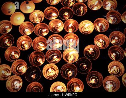 Candele accese con la calda fiamma durante il rito religioso Foto Stock