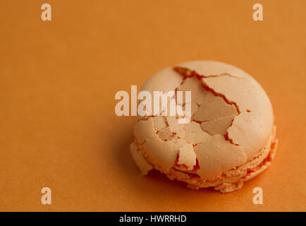 Orange singolo amaretto frantumato su sfondo arancione con copia spazio, soft focus Foto Stock