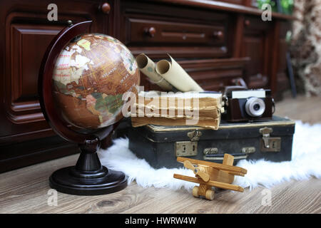 Composizione su un pavimento di legno vintage globe con la vecchia pelle sui Foto Stock