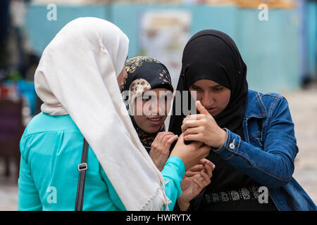 Chefchaouen, Marocco. Giovani donne marocchine la verifica di un telefono cellulare. Foto Stock