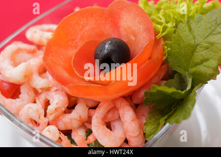 Insalata di pesce con gamberi e verdure fresche, su un serving table. Su una tovaglia rossa close-up. Vista da sopra Foto Stock