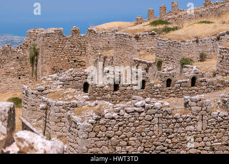 Parete in rovina di antica fortezza Acrocorinth contro il cielo blu su una luminosa giornata di sole. Peloponneso, Grecia. Foto Stock