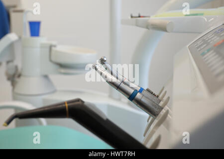 Vista dettagliata del dentista metallico strumenti e esercitazioni sul vassoio con luce di medici in odontoiatria clinica Foto Stock