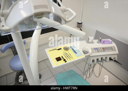 Vista dettagliata del dentista metallico strumenti e esercitazioni sul vassoio con luce di medici in odontoiatria clinica Foto Stock