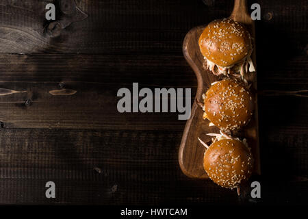 In casa Mini Hamburger di manzo con insalata Coleslaw sul piccolo tagliere di legno. Carne alla Brace panini sul tavolo rustico. Foto Stock