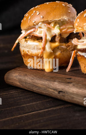 In casa Mini Hamburger di manzo con insalata Coleslaw sul piccolo tagliere di legno. Carne alla Brace panini sul tavolo rustico. Foto Stock