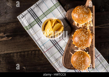 In casa Mini Hamburger di manzo con insalata Coleslaw sul piccolo tagliere di legno. Carne alla Brace panini sul tavolo rustico. Foto Stock