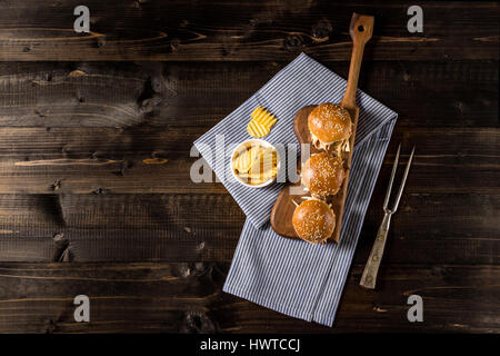 In casa Mini Hamburger di manzo con insalata Coleslaw sul piccolo tagliere di legno. Carne alla Brace panini sul tavolo rustico. Foto Stock