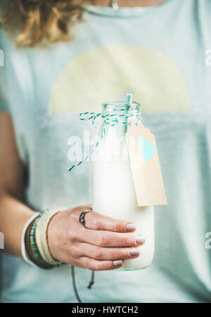 Giovane donna vaso di contenimento di prodotti lattiero-caseari senza latte di mandorla Foto Stock