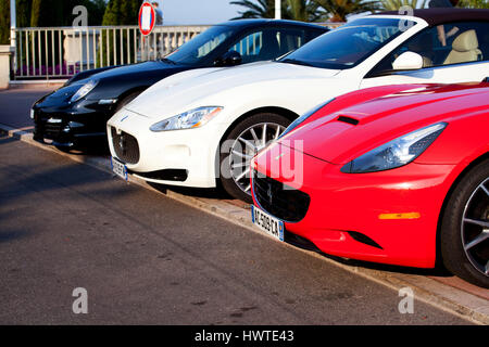 Un rosso Ferrari, Maserati in bianco e nero di un motore Porsche auto parcheggiate accanto a ciascun altro in una strada laterale vicino al Casinò di Monte Carlo, Monaco Foto Stock