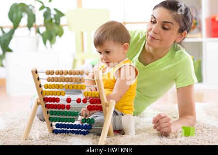 Kid e madre giocando con abacus a casa Foto Stock