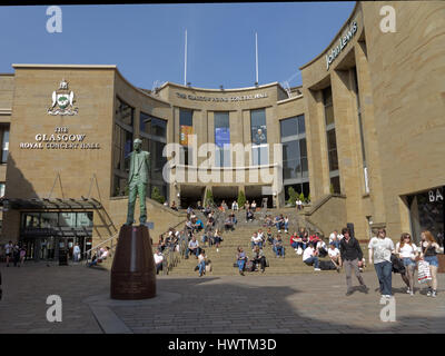 Seduti sui gradini di Sauchiehall Street presso la Glasgow Riyal concert hall di Donald Dewar statua Foto Stock