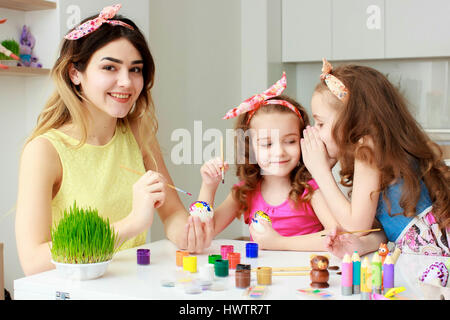 Felice Pasqua. Una madre e figlia di pittura delle uova di Pasqua. La famiglia felice la preparazione per la Pasqua. Grazioso fanciullo ragazza indossando orecchie di coniglietto di Pasqua d Foto Stock