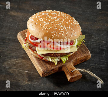 Freschi e saporiti burger on dark tavolo in legno Foto Stock