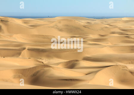 Grandi dune di sabbia. oceano con navi e barca in background. Foto Stock