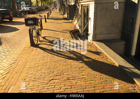 Morningsun getta ombre lunghe in una strada laterale in Amsterdam Foto Stock