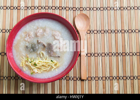 Congee, Farinata di Riso, farinata di riso e zuppa di riso su sfondo di legno, vista dall'alto. Foto Stock