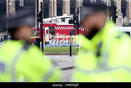 Gli ufficiali di polizia di condurre una ricerca fingertip sulla piazza del Parlamento vicino alla Casa del Parlamento a Londra, dopo sette persone sono state arrestate in raid a Londra, Birmingham e altrove legato al Westminster attacco terroristico. Foto Stock