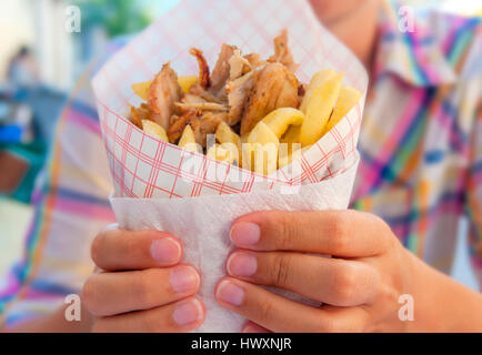 Ragazza con Gyro greco con patate fritte vicino sul tavolo Foto Stock