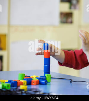 Bambini che giocano con fatti in casa, fai-da-te giocattoli educativi, impilatura e disponendo i pezzi colorati. Apprendimento tramite esperienza, concetto lordo e f Foto Stock