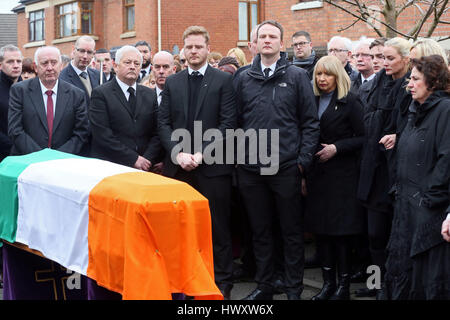 Una bandiera irlandese è collocato sulla bara come membri della famiglia, figli Emmet (centro sinistra) e Fiachra (centro destra), moglie Bernadette (Bernie, estrema destra) guarda sul davanti del funerale del nord irlandese ex vice primo ministro ed ex-IRA commander Martin McGuinness al di fuori di casa sua nel Bogside area di Londonderry. Foto Stock