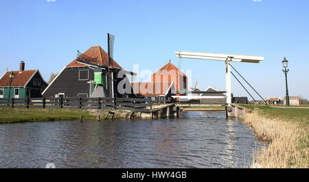 Il mulino a vento, ponte levatoio in legno e case olandesi tradizionali presso il museo all'aria aperta di Zaanse Schans, Zaandam/Zaandijk, Paesi Bassi Foto Stock