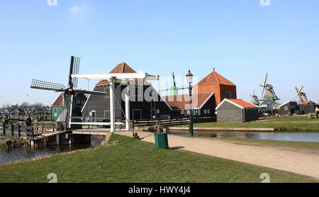 Il mulino a vento, ponte levatoio in legno e case olandesi tradizionali presso il museo all'aria aperta di Zaanse Schans, Zaandam/Zaandijk, Paesi Bassi Foto Stock