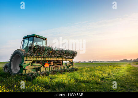 Trattrice agricola in un campo su un Maryland Farm vicino al tramonto Foto Stock