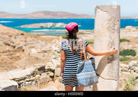 La Grecia, Mykonos, Delos, turista al sito archeologico godendo della vista Foto Stock