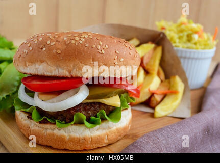 Sandwich hamburger home soft panini, formaggio, pomodori e succosa hamburger. Insalata di cavolo. Le patatine fritte. Fast food. Foto Stock