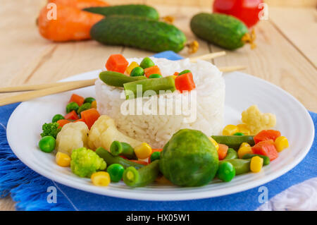 Riso con verdure cotte a vapore su una piastra bianca, disposti in un cerchio. Vegane. Foto Stock