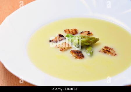 Crema di zuppa di asparagi con tutta l'Asparago Verde teste e crostini. Foto Stock