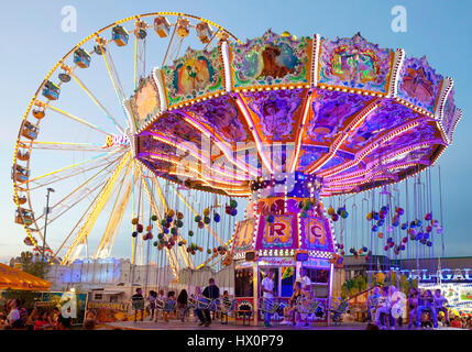 Illuminato giostra oscillante e la ruota panoramica Ferris, Cranger Kirmes, il più grande festival folk nel distretto della Ruhr, Herne Foto Stock