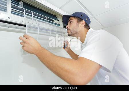 Ritratto di metà maschio adulto tecnico riparare il condizionatore d'aria Foto Stock