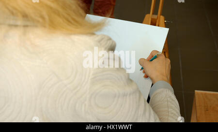 Donna artista disegna uno schizzo a matita in art studio Foto Stock