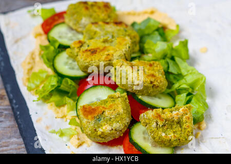 Green open falafel con hummus e le verdure sul pane pita su ardesia e scuro dello sfondo. Amore per un sano cibo vegan concept Foto Stock