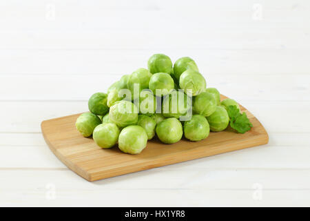 Cumulo di materie cavoletti di Bruxelles sul tagliere di legno Foto Stock