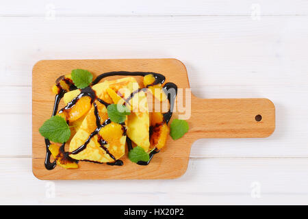 Frittelle di arance e cioccolato topping sul tagliere di legno Foto Stock
