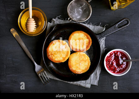 Cheesecake, ricotta frittelle in padella su sfondo scuro, vista dall'alto Foto Stock