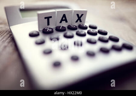 Calcolatrice con la parola scritta fiscale nel blocco di legno lettere Foto Stock