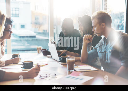 Multirazziale business team fatto di giovani abili dipendenti seduti insieme nella sala riunioni di una moderna azienda Foto Stock