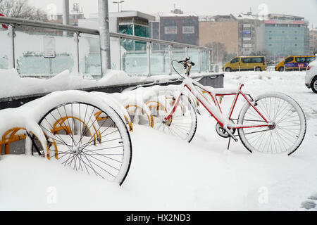 Stock Photo - Istanbul, Turchia - 7 Gennaio 2017: furto di bicicletta sulla neve a Istanbul Kadikoy con alcuni edifici e veicoli. Foto Stock