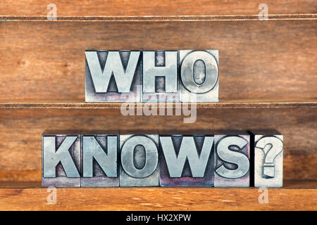 Chi sa domanda fatta dalla stampa in rilievo metallico tipo sul vassoio in legno Foto Stock